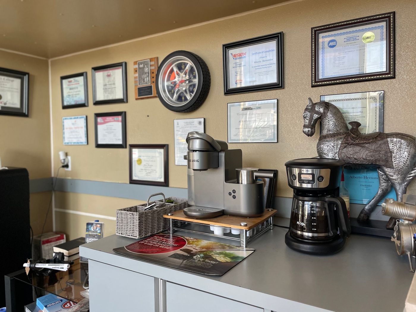 Alberto Hernandez's ASE and training certificates on the office wall